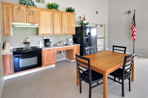 A kitchen with wooden cabinets and a black refrigerator.