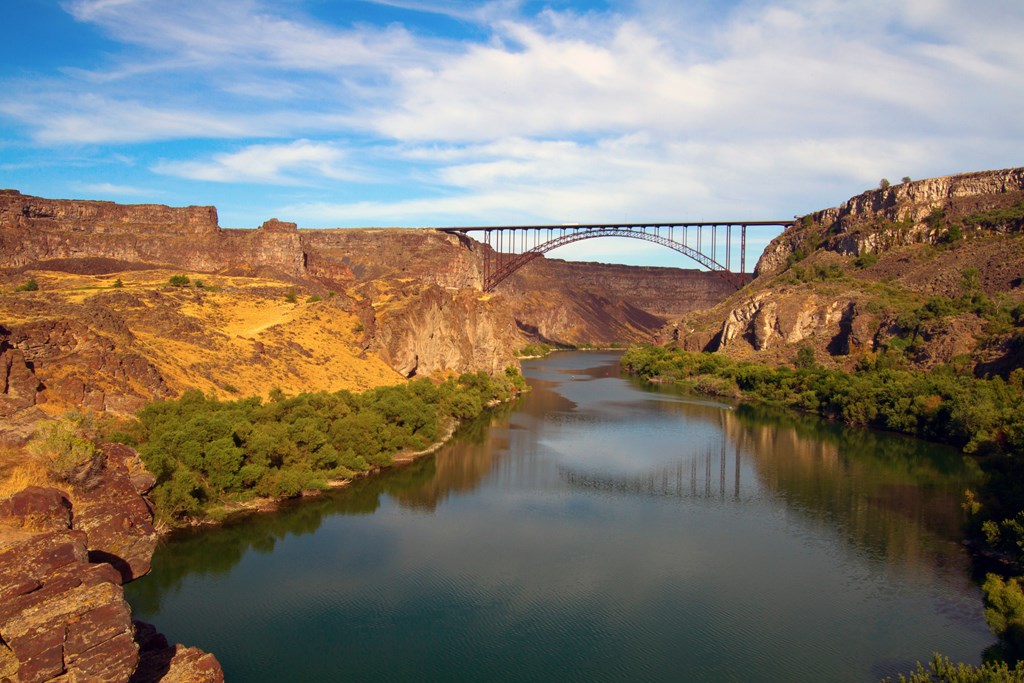 A bridge spans across a river in a canyon.