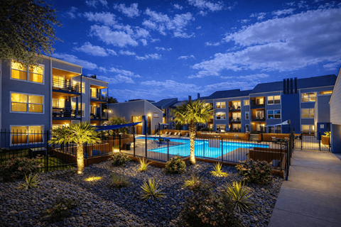 A modern building with a pool in the courtyard at dusk. at Infinity on the Landing Apartments , Apartments, Euless, TX