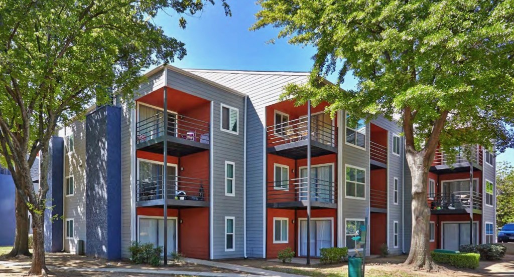 A modern apartment building with balconies and multiple stories at Infinity on the Landing Apartments, Euless, TX, 76040