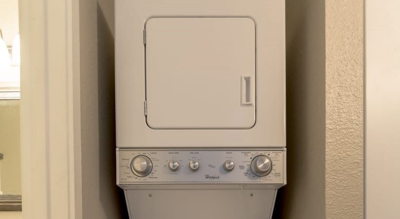 A white washing machine with a door and a control panel at Infinity on the Landing Apartments, Euless, Texas