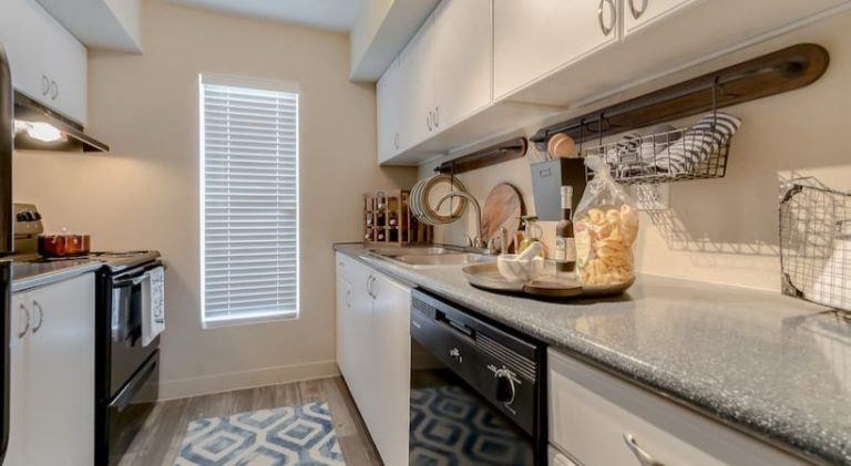 A kitchen with white appliances and a patterned tile floor at Infinity on the Landing Apartments, Euless, TX, 76040