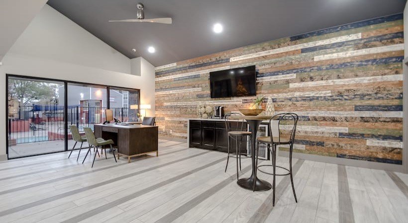 A room with a stone wall and a ceiling fan at Infinity on the Landing Apartments, Euless 76040