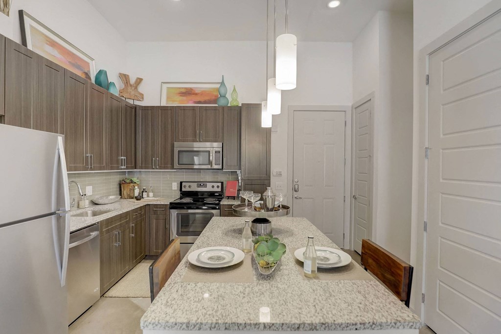 A kitchen with a table set for two at Infinity on the Point Apartments, Dallas, Texas