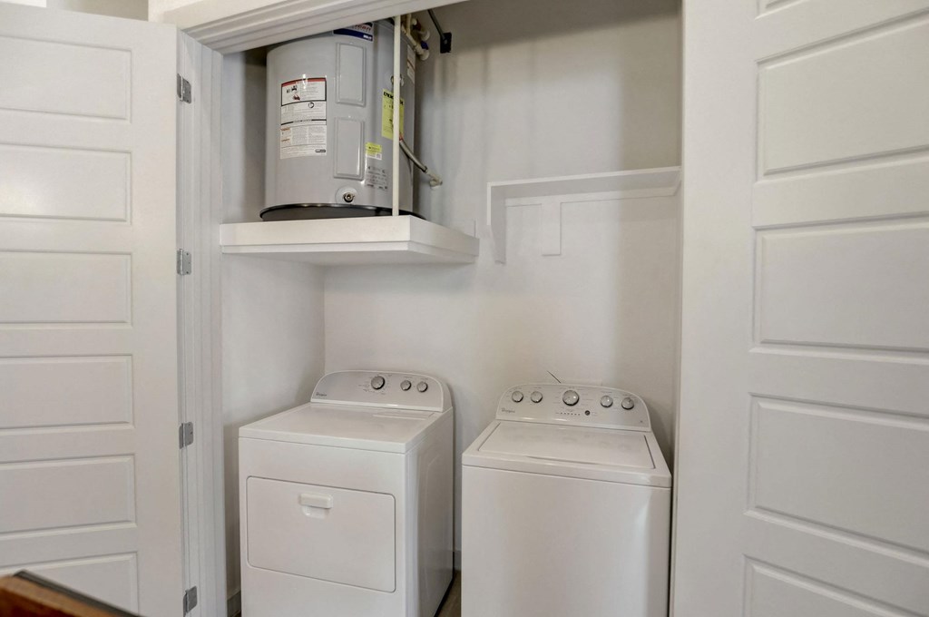 A white washing machine and dryer are in a cabinet at Infinity on the Point Apartments, Dallas, TX, 75243