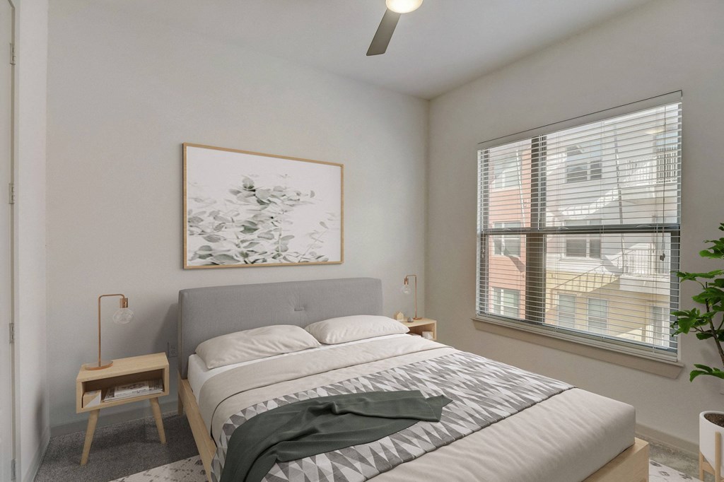 A bedroom with a bed, a nightstand, and a window at Infinity on the Point Apartments, Dallas, Texas