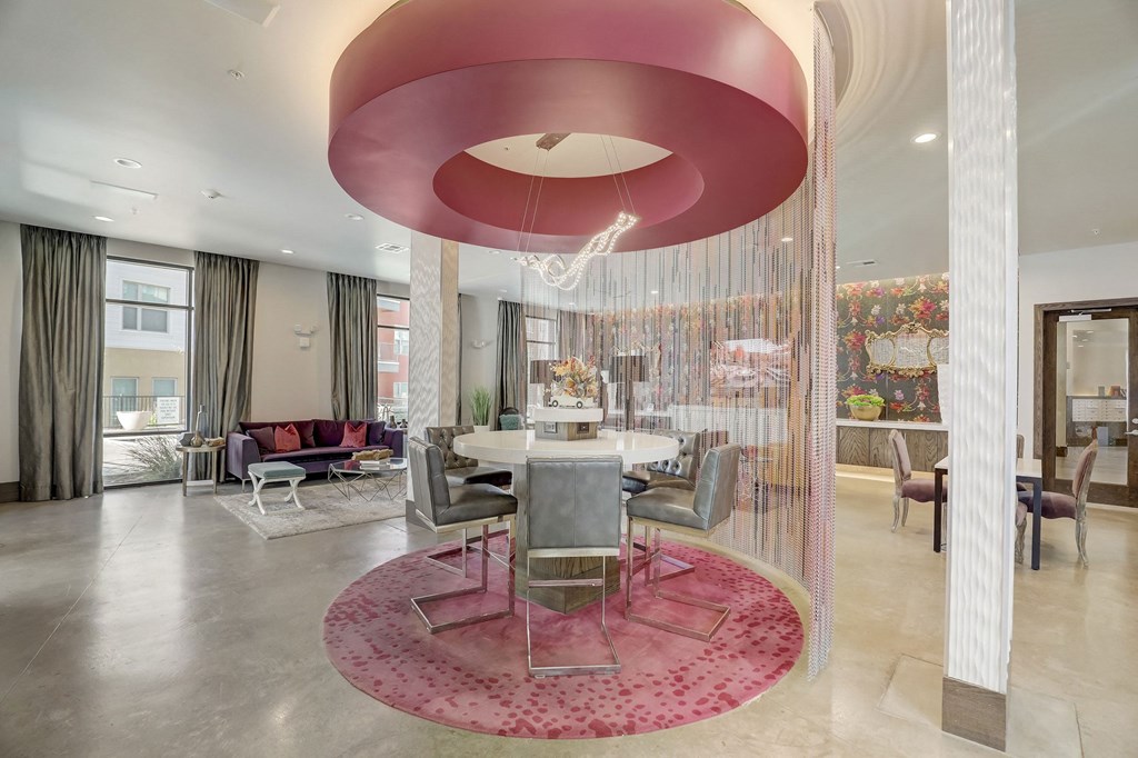A modern living room with a red circular light fixture at Infinity on the Point Apartments, Dallas