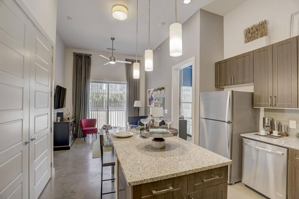 A kitchen with a granite countertop and stainless steel appliances at Infinity on the Point Apartments, Texas, 75243