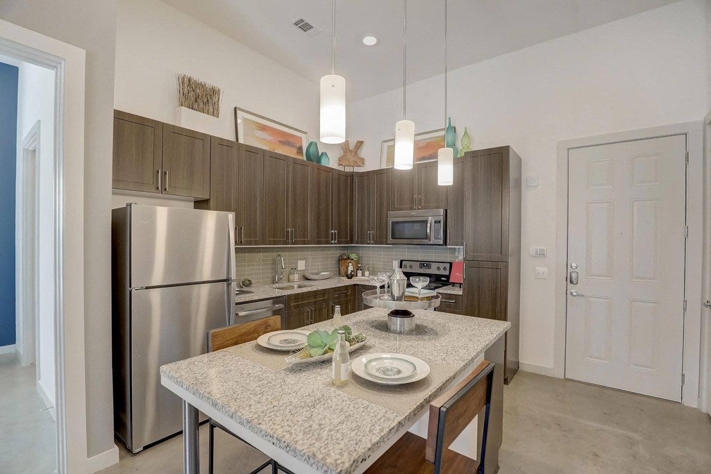 A kitchen with a table set for two with a microwave and oven above at Infinity on the Point Apartments, Dallas, TX, 75243