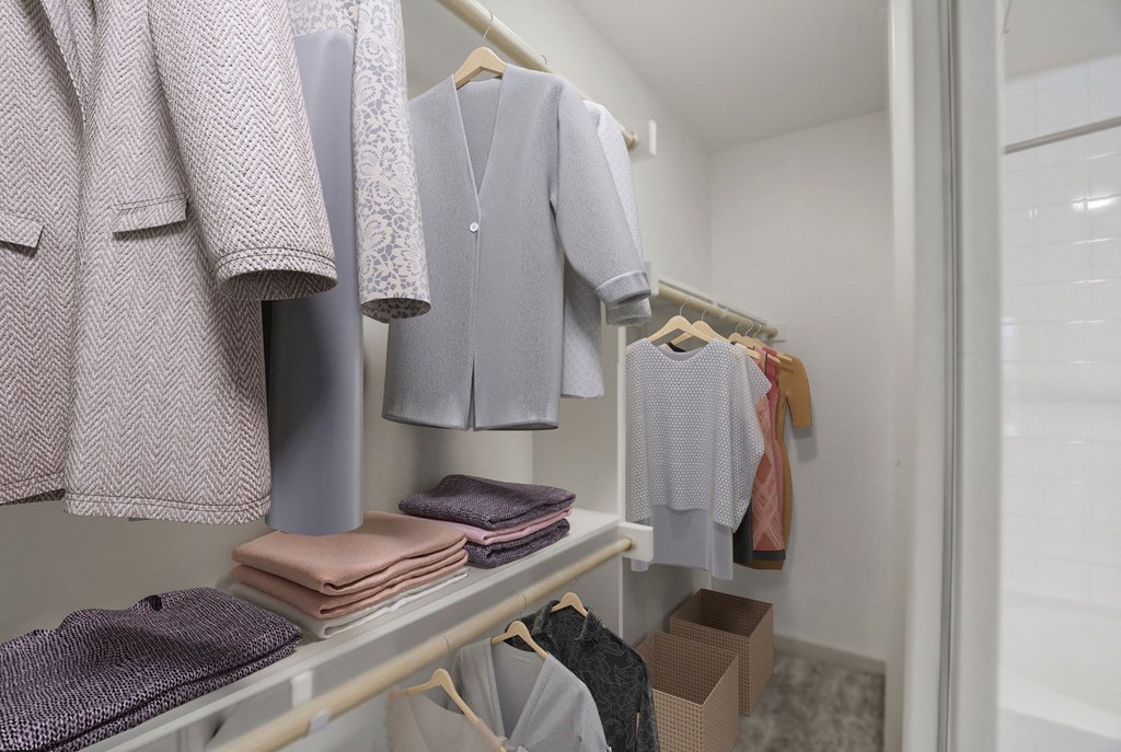 A row of shirts hang on a rack in a closet at Infinity on the Point Apartments, Dallas, TX, 75243