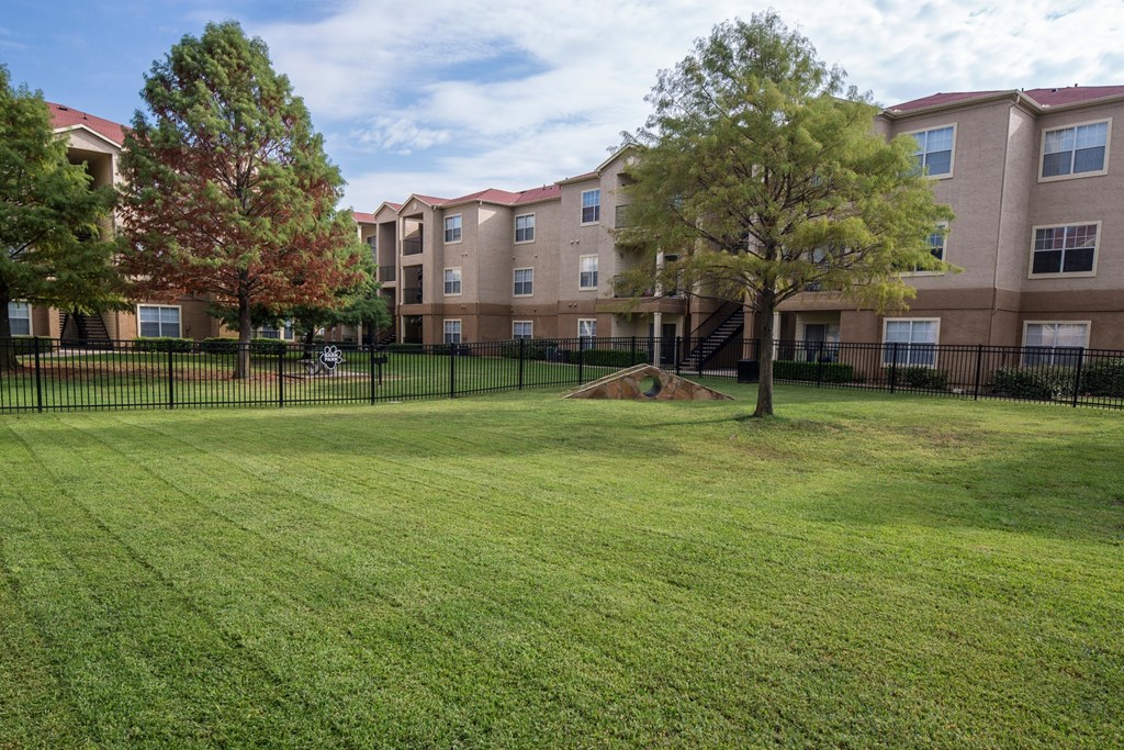A grassy area in front of apartment buildings.
