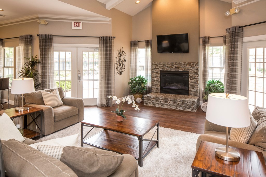 A living room with a fireplace and a flat screen TV mounted above it.