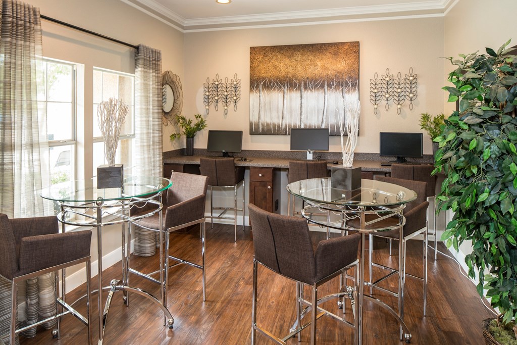 A modern home office with a glass table and chairs.