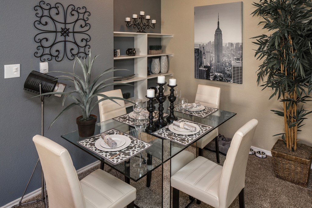 A dining room with a glass table and chairs.