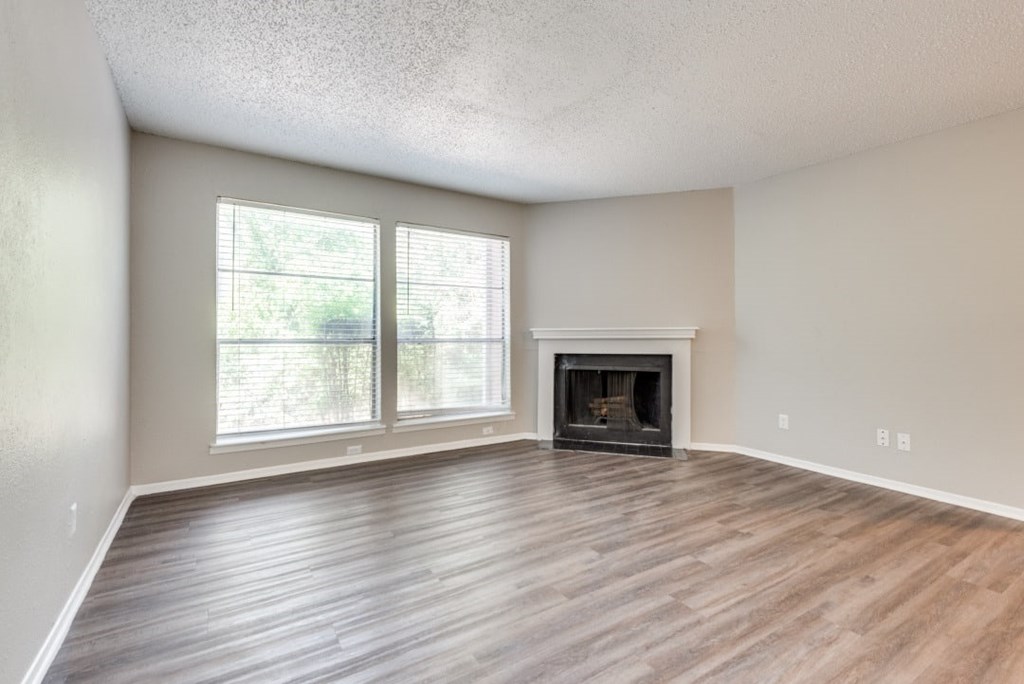 A room with a fireplace and a window at Infinity on the Oaks Apartments, Dallas, Texas
