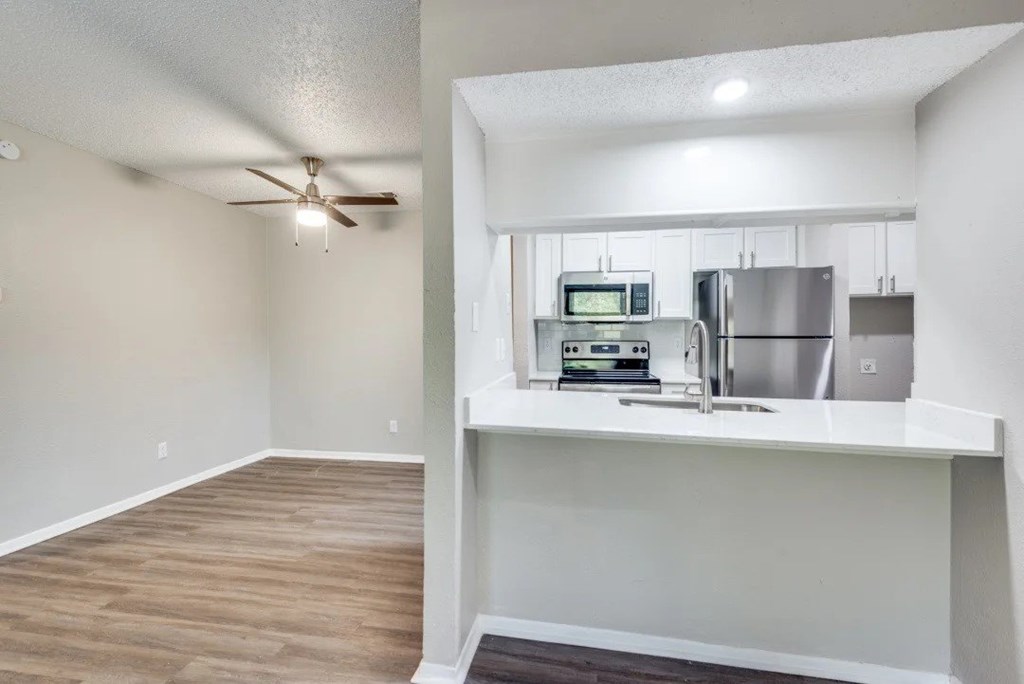 A kitchen with a refrigerator, microwave, and oven at Infinity on the Oaks Apartments, Dallas 75231