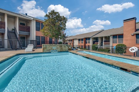 A swimming pool in front of apartment buildings.