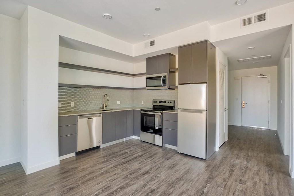 A kitchen with a refrigerator, oven, and microwave.at Catalina West Adams, Los Angeles, 90016