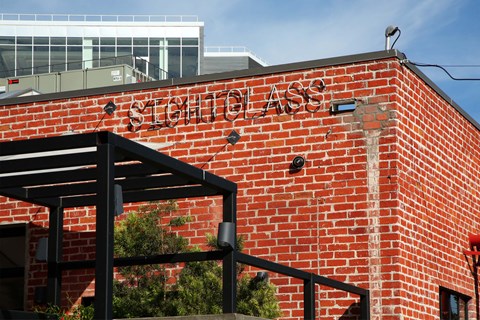 A red brick building with a black awning and the words