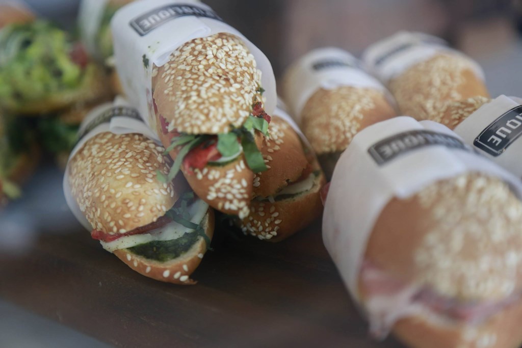 A close up of a sandwich with sesame seeds on a bun. at The Geffen, California, 90038