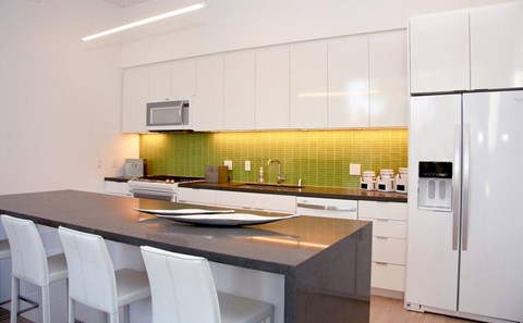 A modern kitchen with white cabinets and a black countertop.