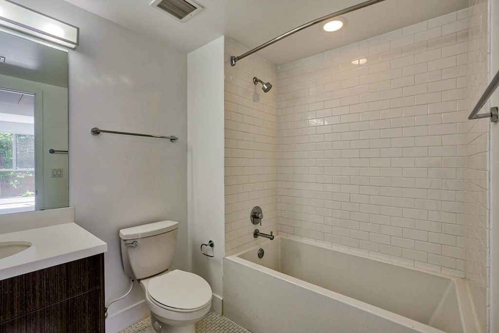 A white bathroom with a toilet, sink, and bathtub.at 1800 Whitley, Los Angeles, 90028