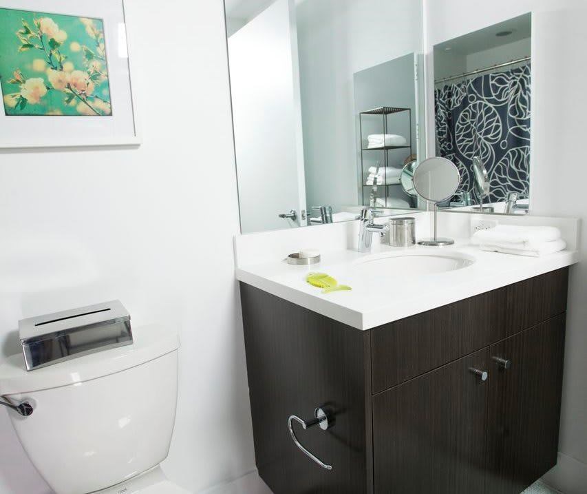 A bathroom with a white toilet and a white sink.at 1800 Whitley, Los Angeles, 90028