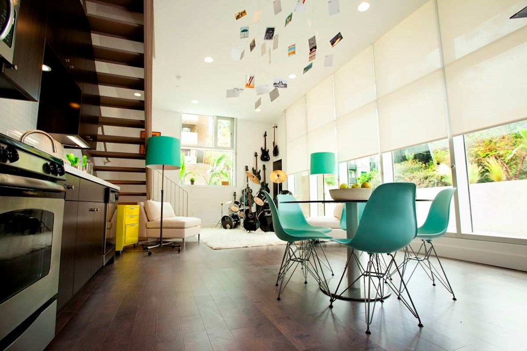 A kitchen with a table and chairs and a staircase.at 1800 Whitley, Los Angeles California