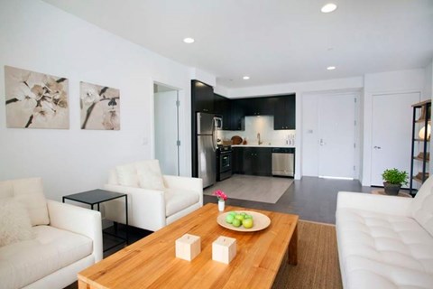 A modern living room with a wooden coffee table and two white couches.
