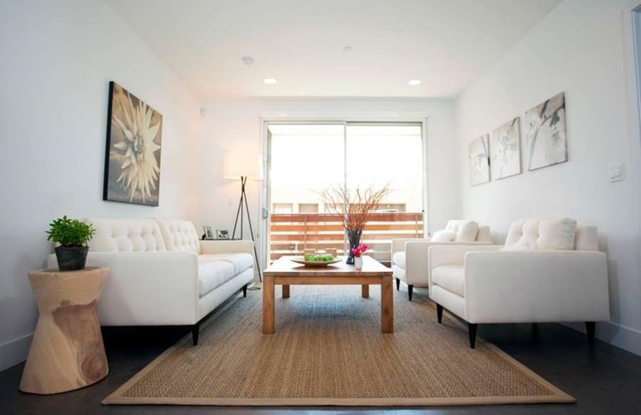 A living room with a white couch, a wooden coffee table, and a rug.at 1800 Whitley, Los Angeles, CA