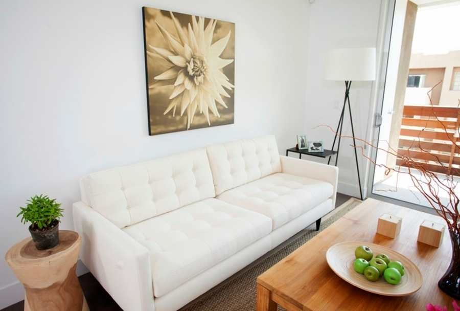 A white couch sits in a living room with a wooden table in front of it.at 1800 Whitley, California