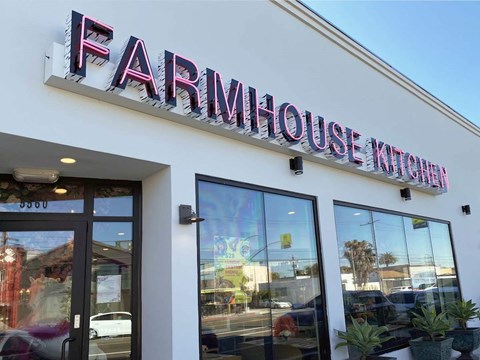 A white building with a sign that says Farmhouse Kitchen.