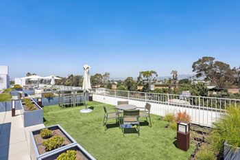 A patio with a table and chairs overlooks a cityscape.