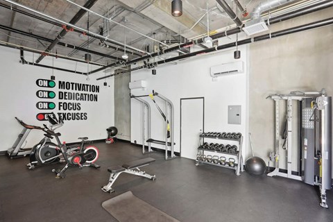 A gym with a white wall that has a list of motivational words on it.