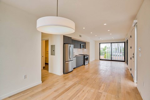 A modern kitchen with wooden floors and stainless steel appliances.