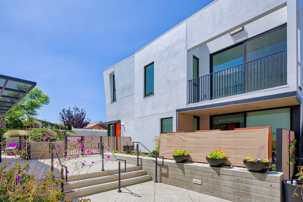 A modern house with a concrete exterior and a balcony with a railing.at 810 Ashland, Santa Monica, 90405