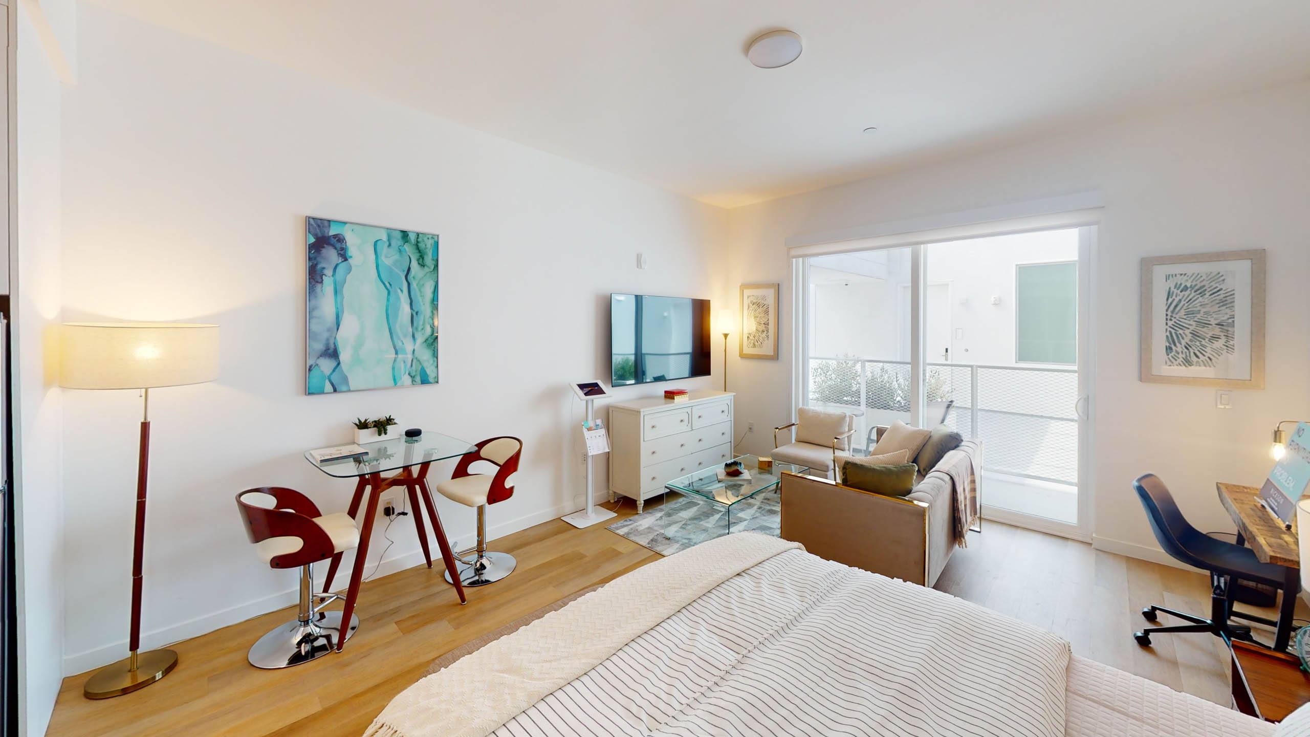 A living room with a red chair and a painting on the wall.