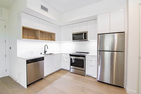 A kitchen with white cabinets and stainless steel appliances.