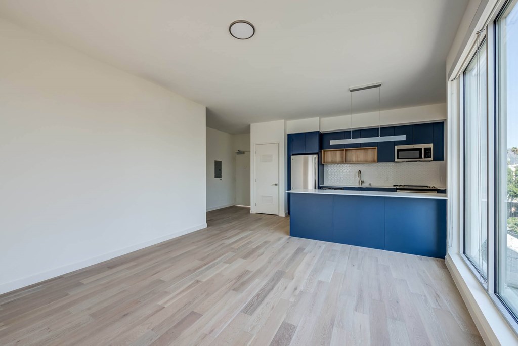A kitchen with blue cabinets and a wooden floor.at Junction 4121, Los Angeles