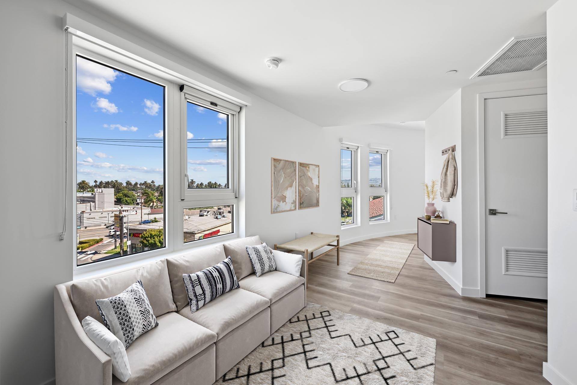 A living room with a couch and a large window.