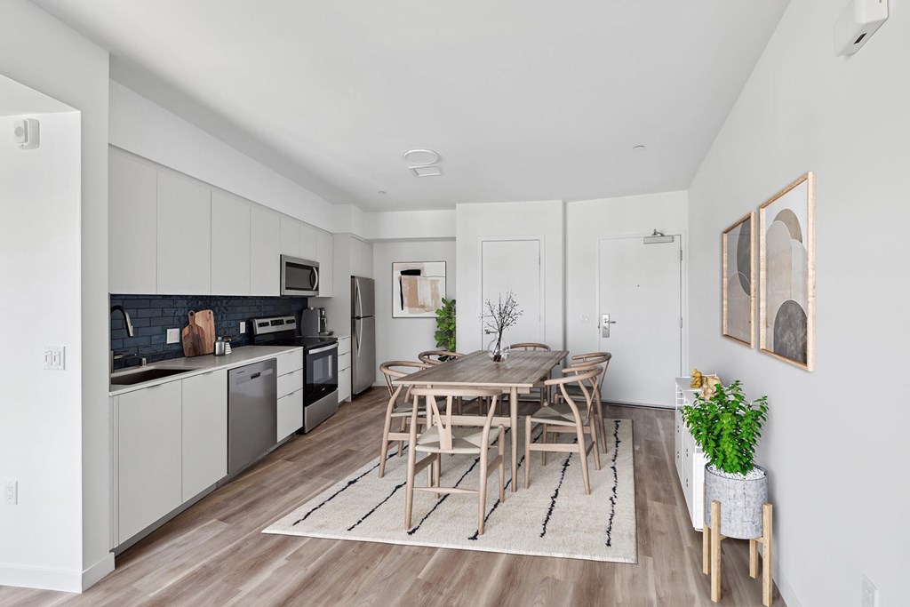 A modern kitchen with a dining table and chairs.