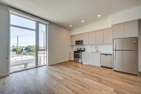 A kitchen with white cabinets and a wooden floor.