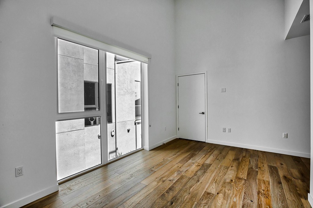 A room with wooden floors and a sliding glass door.at 5263 W Adams, Los Angeles, CA
