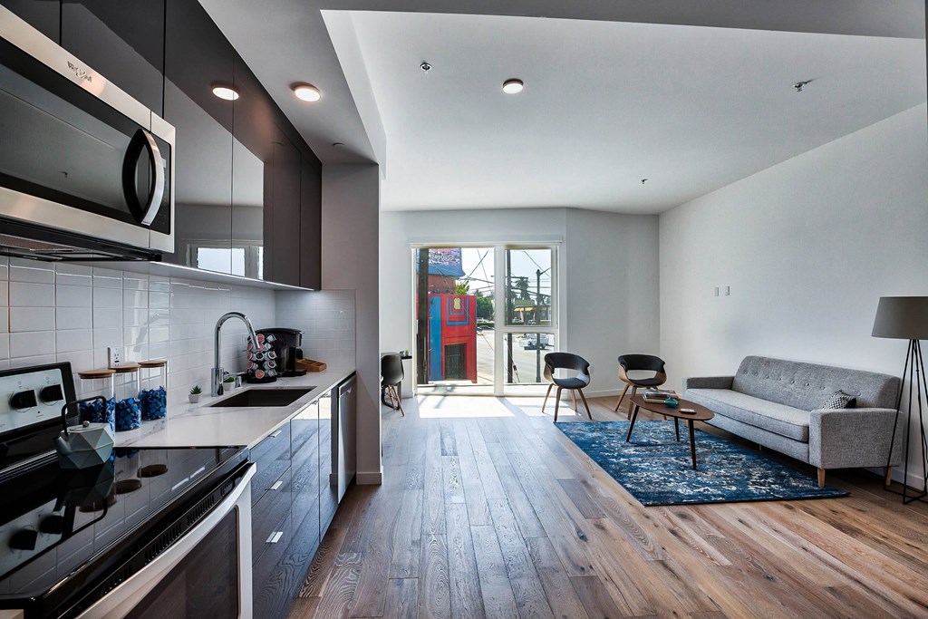 A modern kitchen with a wooden floor and a large window.at 5263 W Adams, Los Angeles, CA 90016