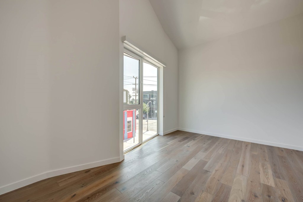 A room with wooden flooring and a large window.at 5263 W Adams, Los Angeles, 90016