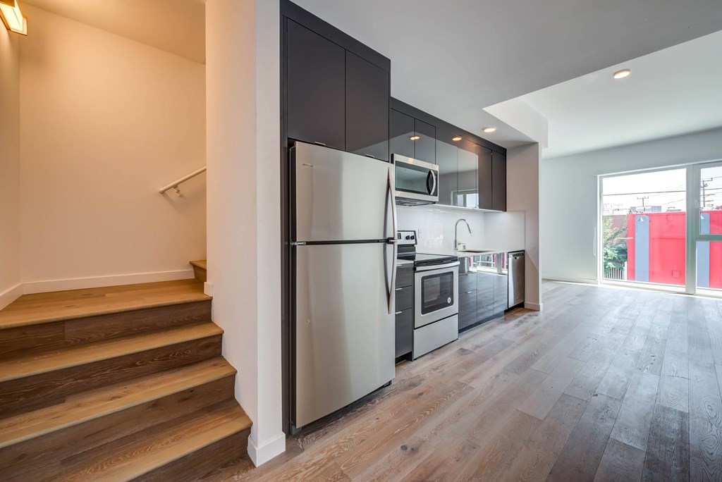 A modern kitchen with a refrigerator, microwave, and oven.at 5263 W Adams, Los Angeles, CA 90016