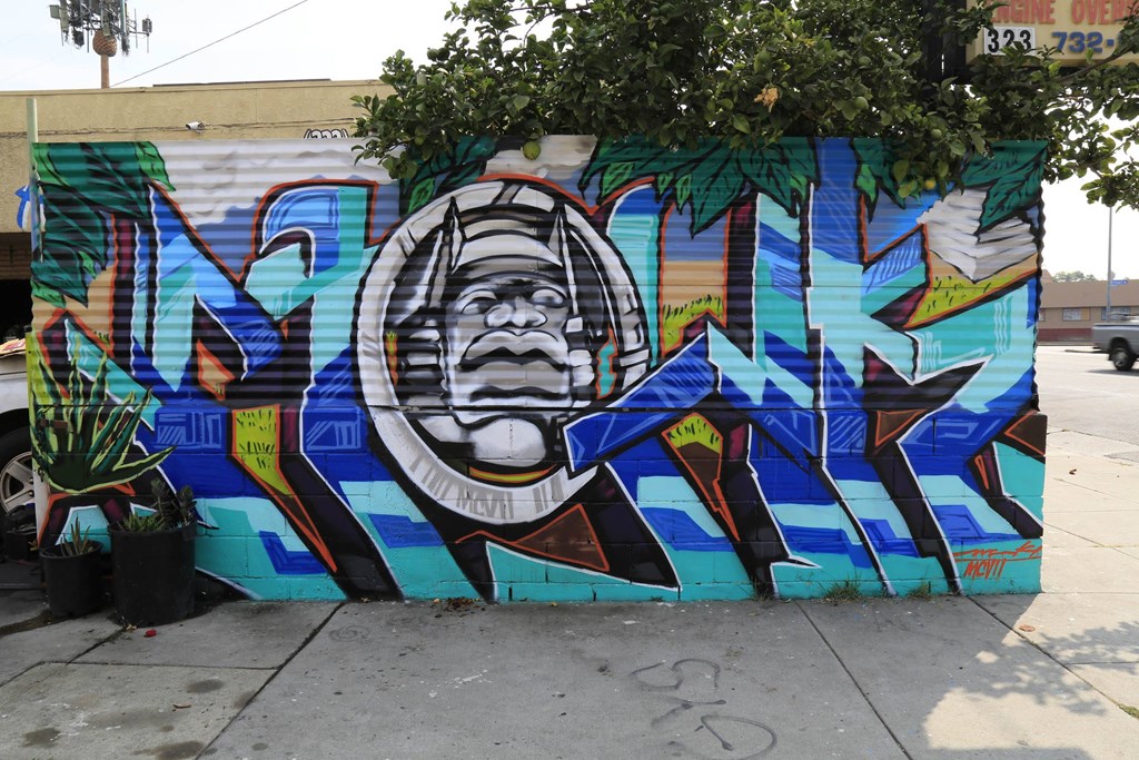 A mural of a man's face with a helmet on his head is painted on a wall.at 5263 W Adams, California, 90016