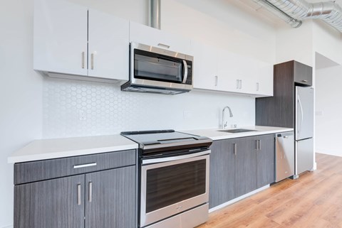 A modern kitchen with a stainless steel oven and microwave.