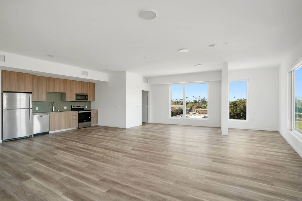 A spacious kitchen with wooden floors and a refrigerator.at 2221 S Western, Los Angeles California