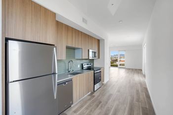 A modern kitchen with a refrigerator, sink, and stove.at 2221 S Western, California